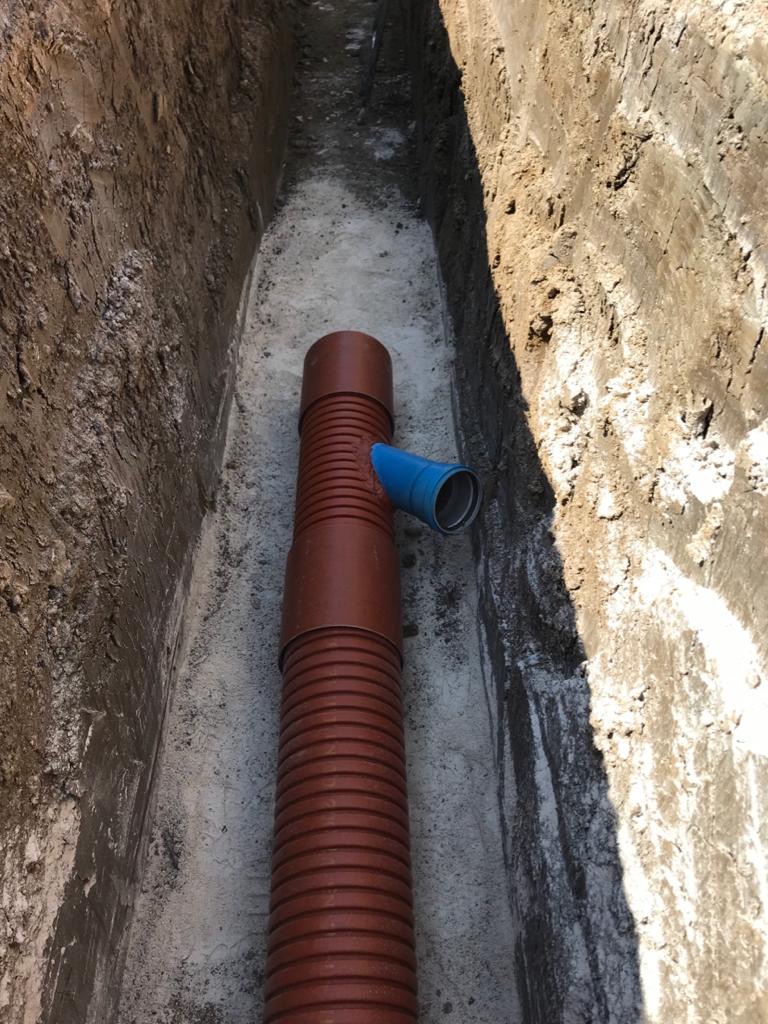 Tubo di scarico in un fossato scavato nel terreno.