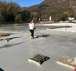 Uomo livella cemento in un cantiere all'aperto.