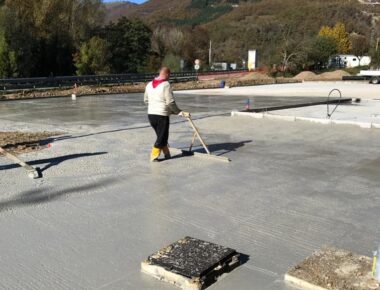 Uomo livella cemento in un cantiere all'aperto.