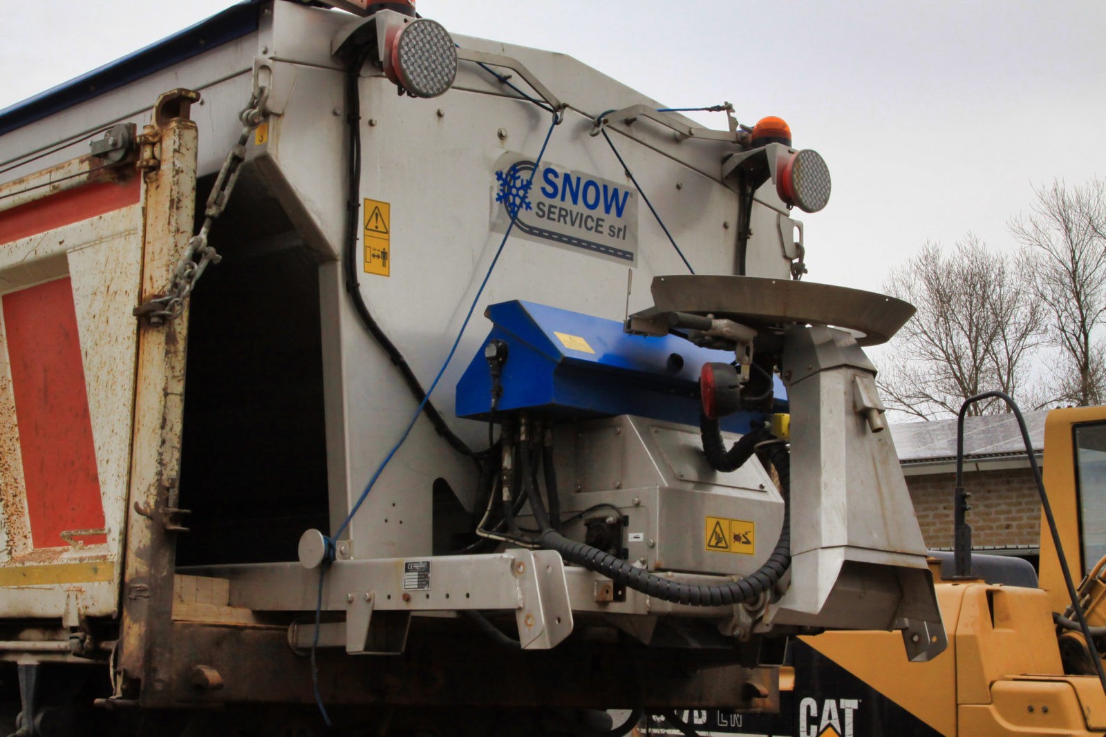 Macchina spargisale con logo "Snow Service srl".