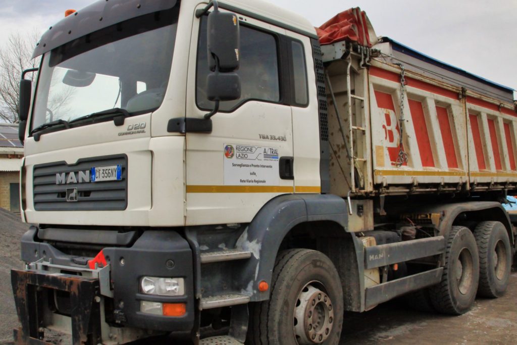 Camion bianco con cassone ribaltabile parcheggiato.
