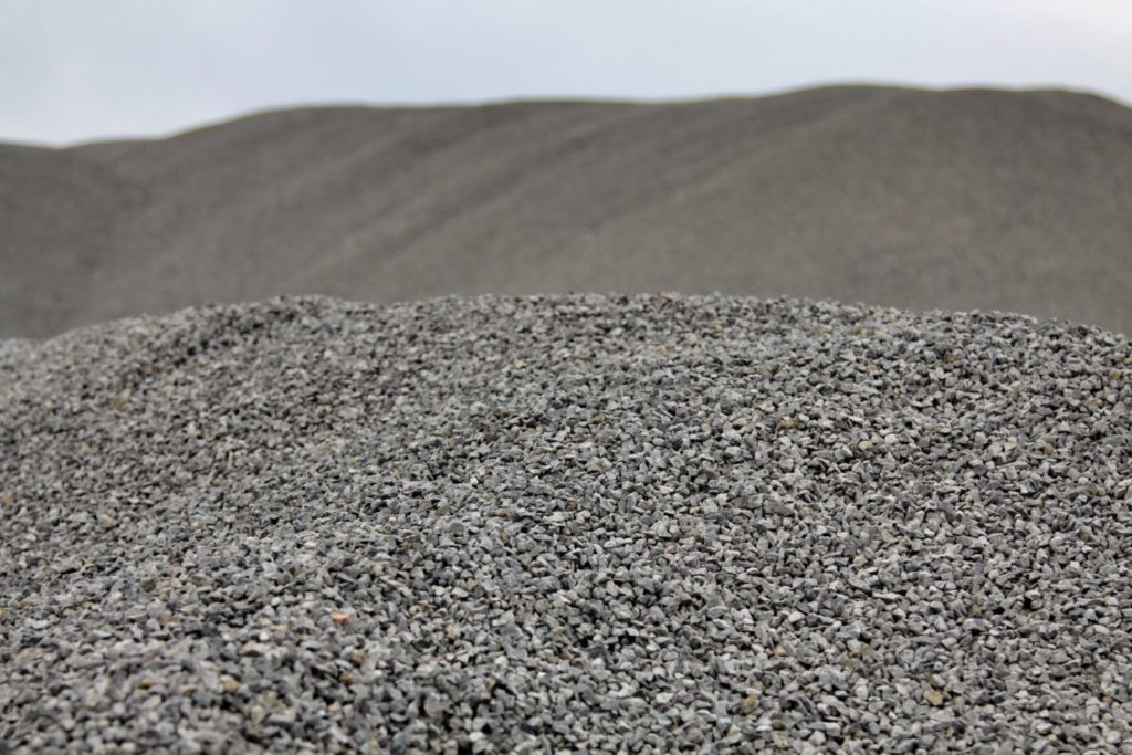 Cumuli di ghiaia grigia su sfondo sfocato.