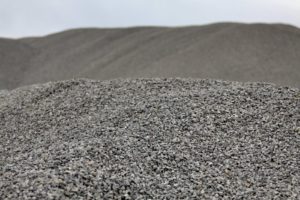 Cumuli di ghiaia grigia su sfondo sfocato.