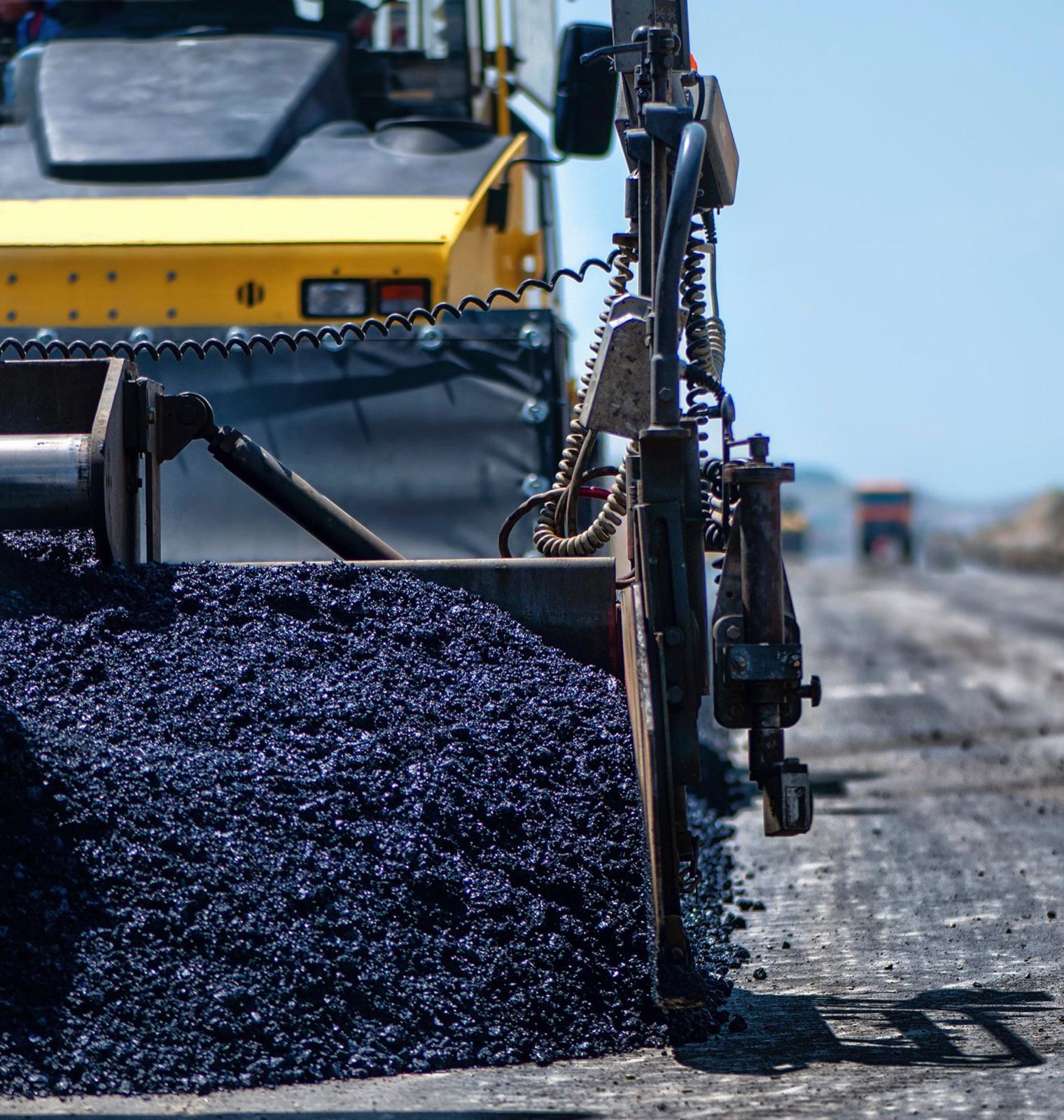 Macchina asfaltatrice in azione su strada.