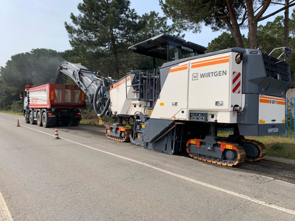 Macchina fresatrice Wirtgen e camion su strada.