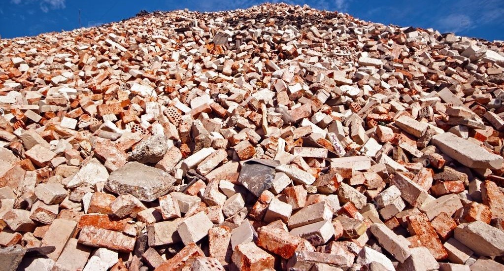 Cumulo di mattoni rotti sotto un cielo blu.