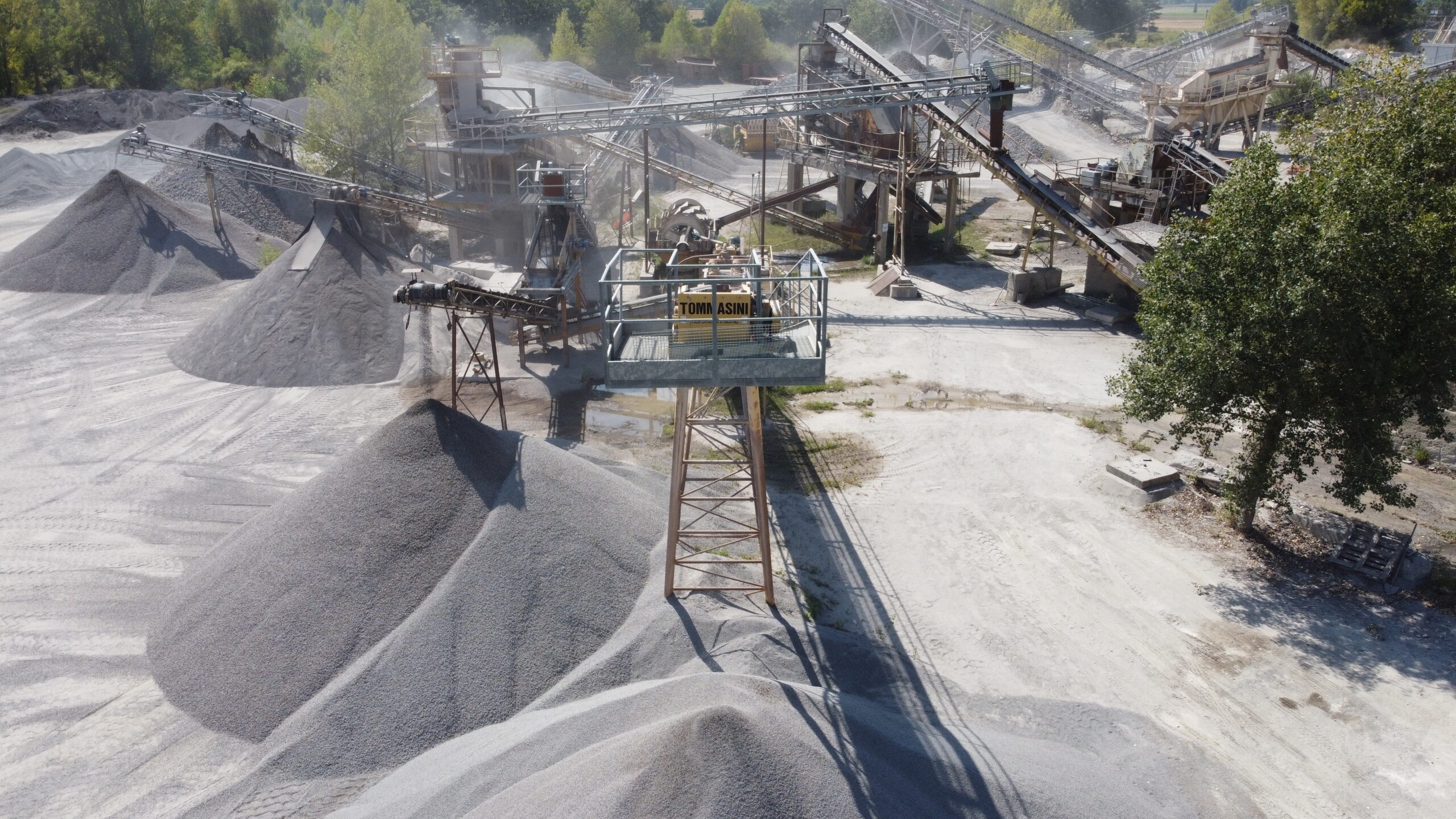 Impianto di lavorazione ghiaia con cumuli e nastri trasportatori.