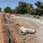 Operai lavorano su un cantiere stradale con materiali edili.