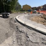 Cantiere stradale con operai e attrezzature edili.