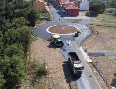 Costruzione di una rotonda stradale con macchinari e operai.