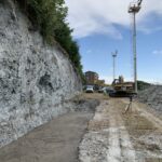 Cantiere con escavatore, terrapieno e attrezzature di costruzione.