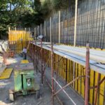 Cantiere edile con operai e strutture in costruzione.