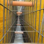 Struttura in costruzione con armature metalliche e pannelli gialli.