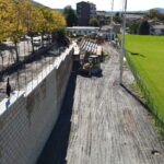 Cantiere con muro in costruzione e macchinari.