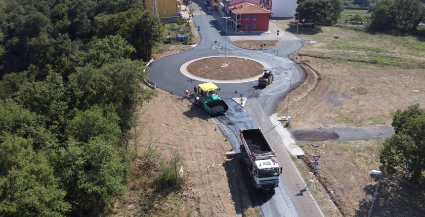 Costruzione di una rotonda stradale con macchinari e operai.