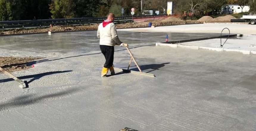 Uomo livella cemento in un cantiere all'aperto.